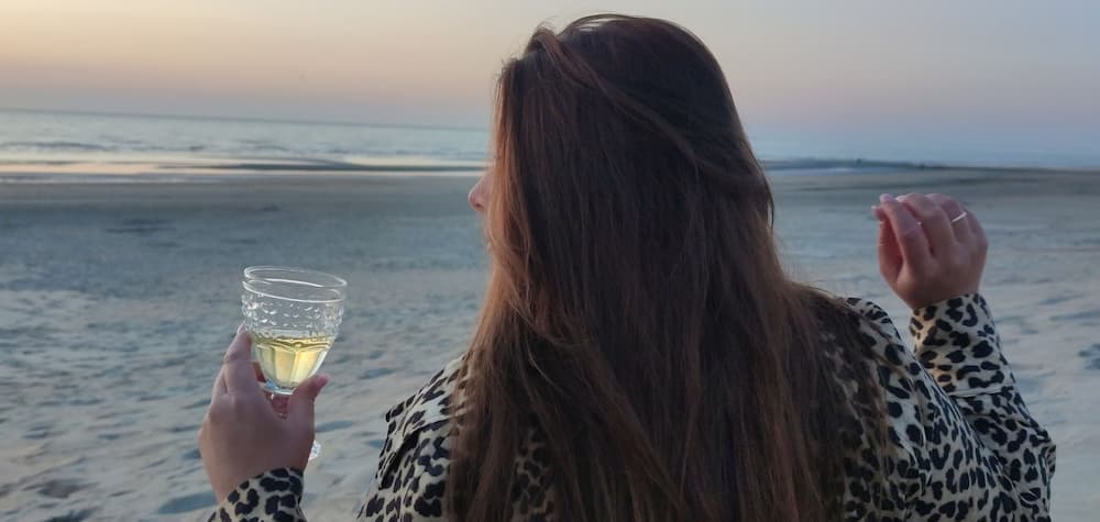 Janina Peters am Strand mit Sektglas Personenmarke Expertin Branding und Design Online-Kurs-Design
